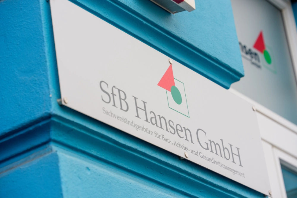 Das Team der SfB Hansen GmbH in Arbeitskleidung bei der Projektbesprechung